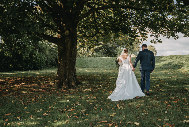 A bride and groom outside beneath a tree